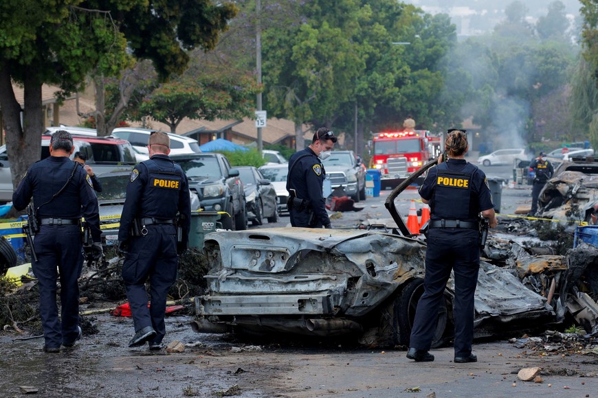 Emergency personnel work at the crash scene on a street, after a small civilian aircraft went down in a military neighborhood in San Diego, California, U.S. May 22, 2025.  REUTERS/Mike Blake     TPX IMAGES OF THE DAY