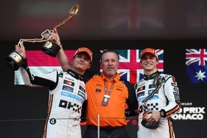 Formula One F1 - Monaco Grand Prix - Circuit de Monaco, Monaco - May 25, 2025
McLaren's Lando Norris celebrates with a trophy on the podium after winning the Monaco Grand Prix alongside third placed McLaren's Oscar Piastri and McLaren chief executive Zak Brown REUTERS/Jakub Porzycki