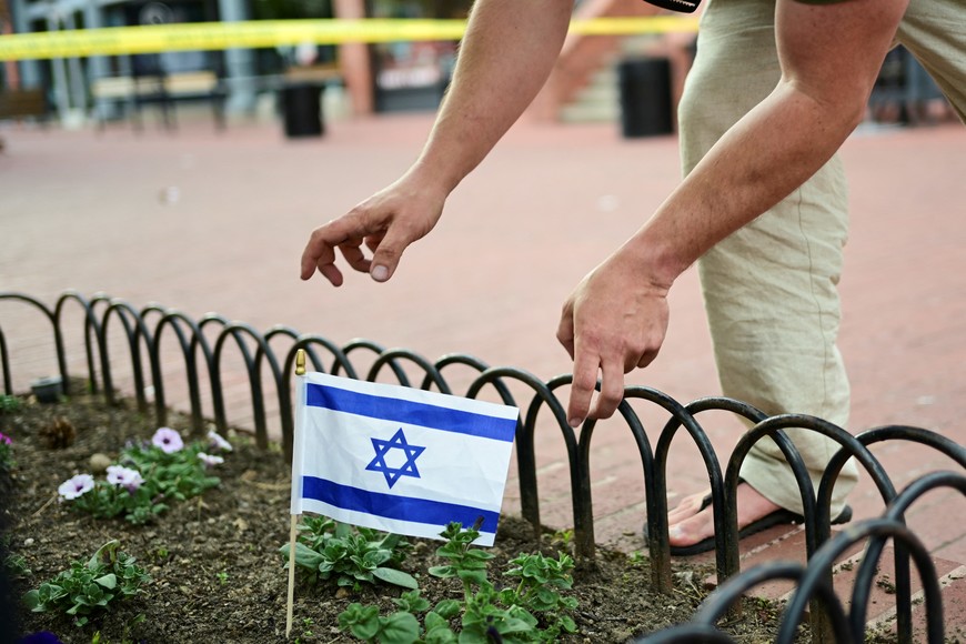 Sam King places an Israeli flag on the ground, near the scene of an attack that injured multiple people, in Boulder, Colorado, U.S. June 1, 2025.  REUTERS/Mark Makela