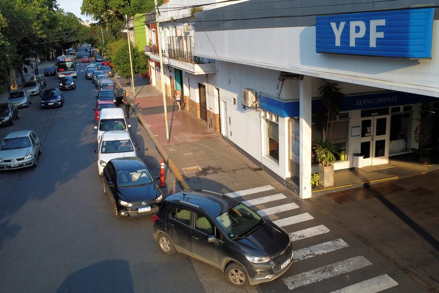 Cars queue outside a YPF gas station to fill up, ahead of upcoming price increasements, after Argentina's peso plunged 50% following devaluation, in Buenos Aires, Argentina, December 13, 2023. REUTERS/Agustin Marcarian
