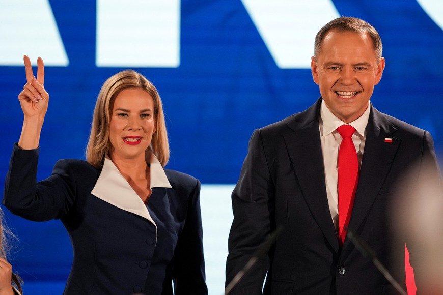 Polish presidential candidate Karol Nawrocki, backed by the main opposition Law and Justice (PiS) party, and his wife Marta Nawrocka gesture as they react to the exit polls of the second round of presidential election, in Warsaw, Poland, June 1, 2025. REUTERS/Aleksandra Szmigiel