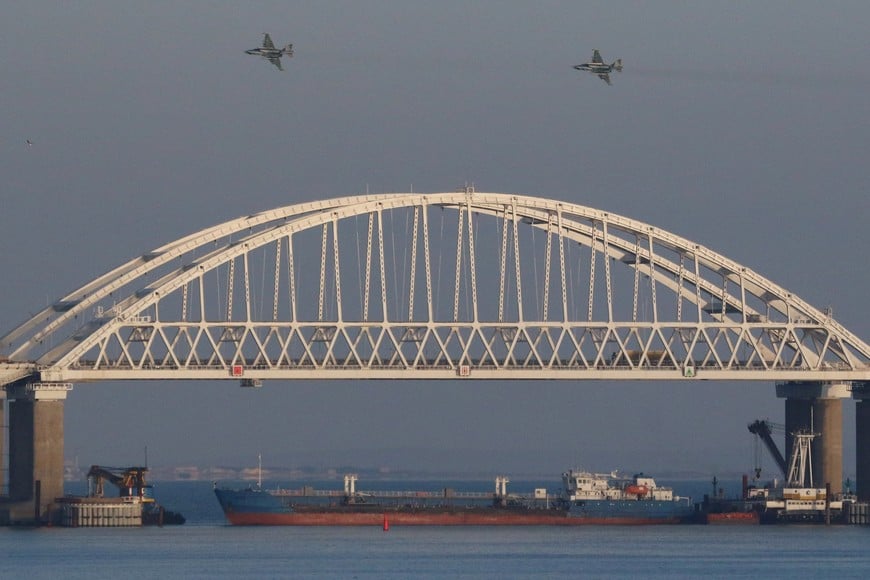 Russian jet fighters fly over a bridge connecting the Russian mainland with the Crimean Peninsula with a cargo ship beneath it after three Ukrainian navy vessels were stopped by Russia from entering the Sea of Azov via the Kerch Strait in the Black Sea, Crimea November 25, 2018. REUTERS/Pavel Rebrov     TPX IMAGES OF THE DAY