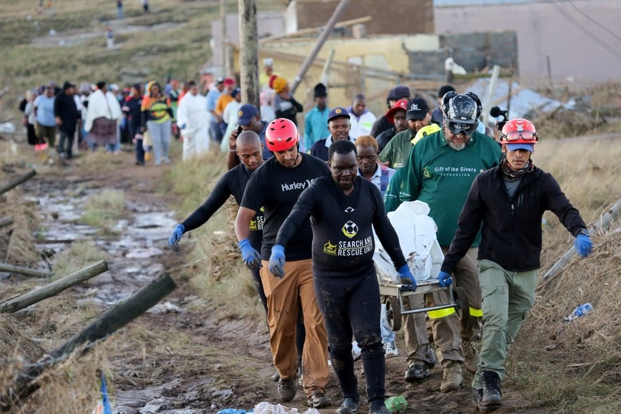Rescue workers carry the covered body of a victim as the death toll from floods continues to rise, in Mthatha, Eastern Cape province, South Africa, June 12, 2025. REUTERS/Stringer     TPX IMAGES OF THE DAY