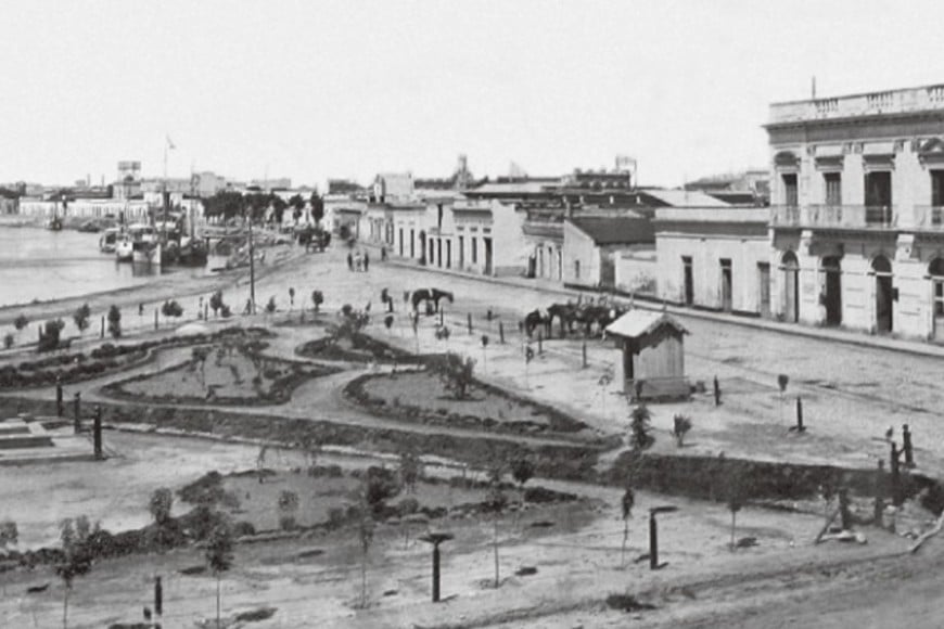 Santa Fe, hacia 1905. Plazoleta del Puerto, actual Plaza Cristóbal Colón. En sus jardines puede observarse la pirámide conmemorativa del Descubrimiento de América, la que hoy se encuentra en Plaza España. A la derecha, en la calle Rivadavia, desde La Rioja a Salta, el edificio de la empresa naviera de Carlos Sarsotti.