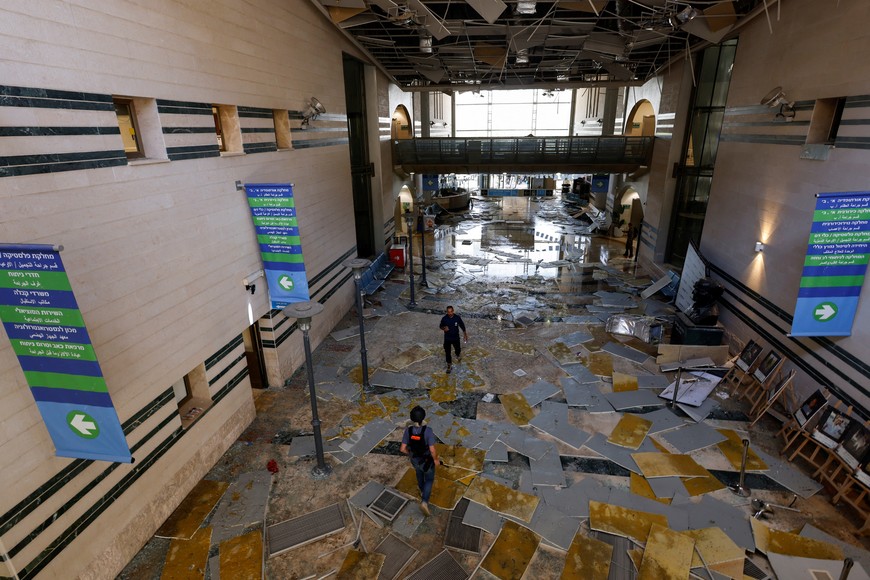 People walk at an impact site, following a missile strike from Iran on Israel, at Soroka Medical Center, in Be'er Sheva, Israel June 19, 2025. REUTERS/Amir Cohen