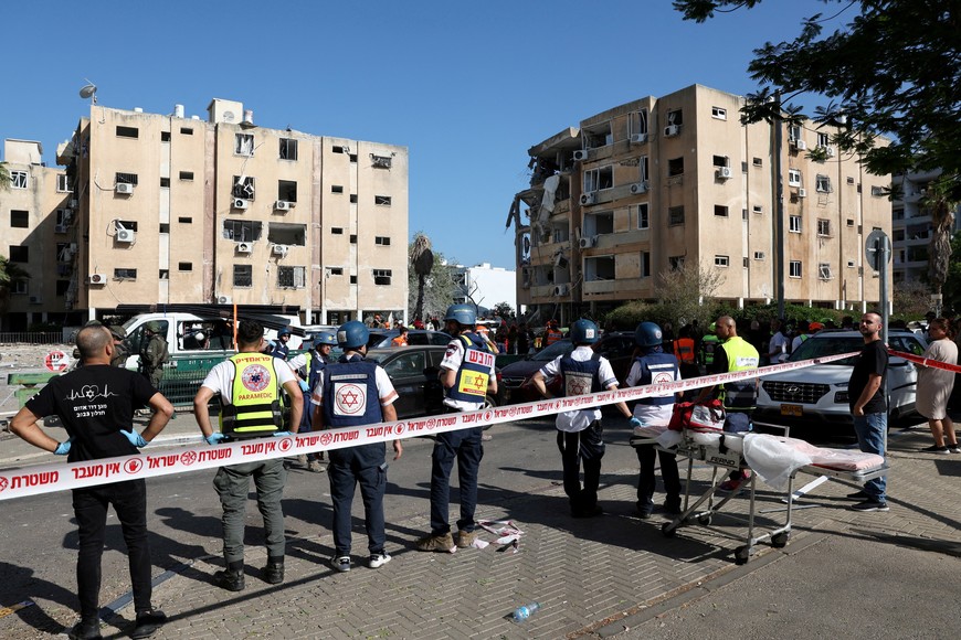 Emergency personnel gather at an impact site following a missile strike from Iran on Israel, in Holon, Israel June 19, 2025. REUTERS/Violeta Santos Moura
