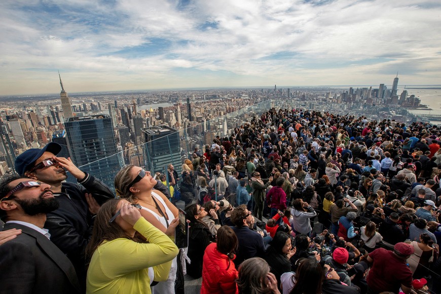People watch the partial solar eclipse as they gather on the observation deck of Edge at Hudson Yards in New York City, New York, U.S., April 8, 2024. REUTERS/Eduardo Munoz SEARCH "REUTERS BEST 2024" FOR THIS STORY. SEARCH "REUTERS YEAR-END" FOR ALL 2024 YEAR END GALLERIES. TPX IMAGES OF THE DAY