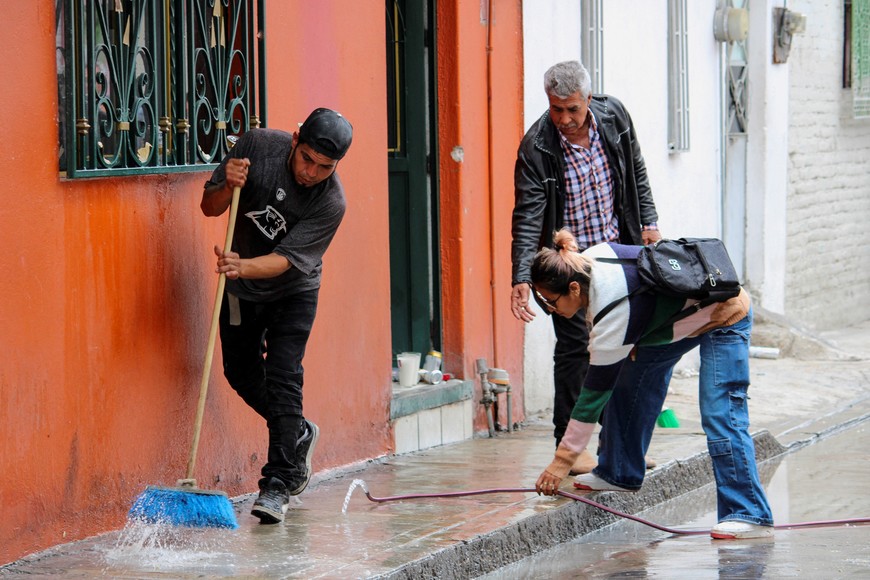 Residents wash blood stains outside a house after gunmen opened fire on Tuesday during a party celebrating the Nativity of John the Baptist, leaving several casualties, in Irapuato, Guanajuato state, Mexico June 25, 2025. REUTERS/Juan Moreno