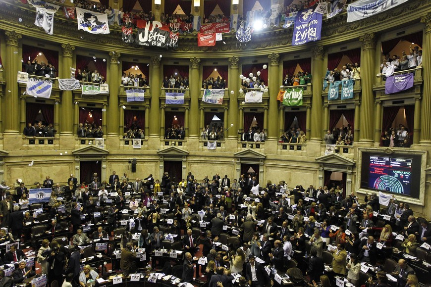 La Cámara de Diputados convirtió en ley esta noche el proyecto que establece la expropiación del 51 por ciento de las acciones de la empresa española Repsol en la petrolera YPF con 208 votos afimativos en general.
Lawmakers celebrate after voting in the Argentine Congress over the nationalization of Argentina's biggest oil company YPF in Buenos Aires May 3, 2012. Argentina's Congress nationalized the country's biggest oil company, YPF, by an overwhelming lower house vote that underscored wide popular support for a measure that has rattled foreign investors and trade partners.The Chamber of Deputies voted 207-32 in favor of expropriating YPF, clearing the way for President Cristina Fernandez to sign the bill into law. The Senate last week approved the measure by a similarly overwhelming margin. REUTERS/Enrique Marcarian (ARGENTINA - Tags: POLITICS ENERGY BUSINESS) buenos aires  sesion camara diputados congreso nacional expropiacion el 51 por ciento de las acciones de la petrolera YPF aprobacion en general ley ypf declaran soberania hidrocarburifera
