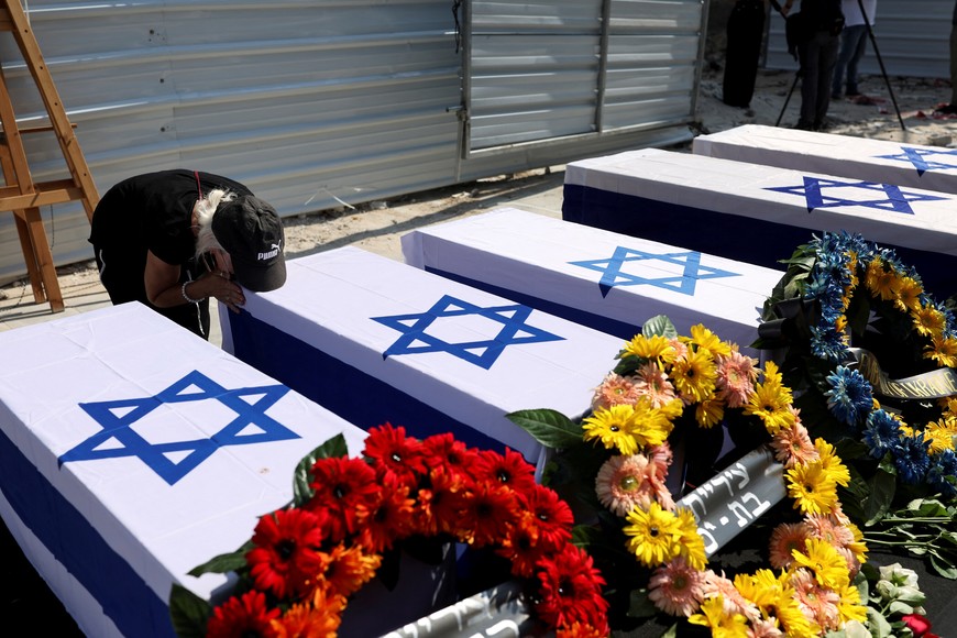 A woman bows over a coffin at a memorial service ceremony next to the residential building that was hit by a missile fired from Iran towards Israel on June 15, 2025 and caused the death of five Ukrainians citizens, in Bat Yam, Israel June 30, 2025. REUTERS/Ronen Zvulun