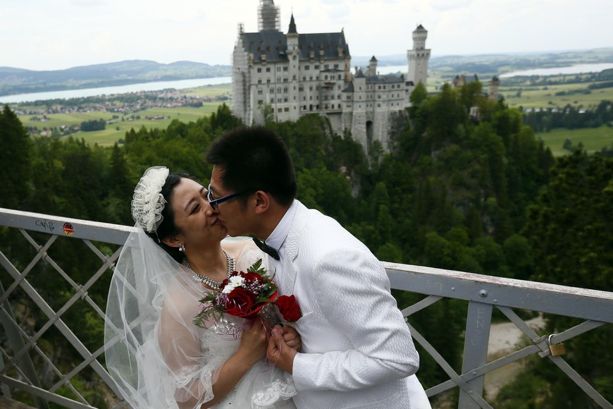 A Chinese bridal couple kiss as they pose in front of the Neuschwanstein castle after their symbolic wedding in Fuessen May 31, 2012.  Some 15 Chinese couples who already married in China, travelled to Germany to repeat their promise of marriage at Neuschwanstein Castle, one of the most popular destinations in Europe.   REUTERS/Michael Dalder(GERMANY - Tags: SOCIETY TRAVEL) alemania  chinos que se casan en alemania castillo de Neuschwanstein