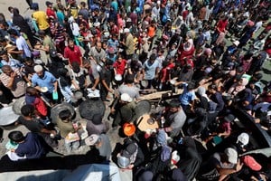 Palestinians gather to receive food from a charity kitchen, amid a hunger crisis, in Nuseirat, central Gaza Strip, July 20, 2025. REUTERS/Ramadan Abed
