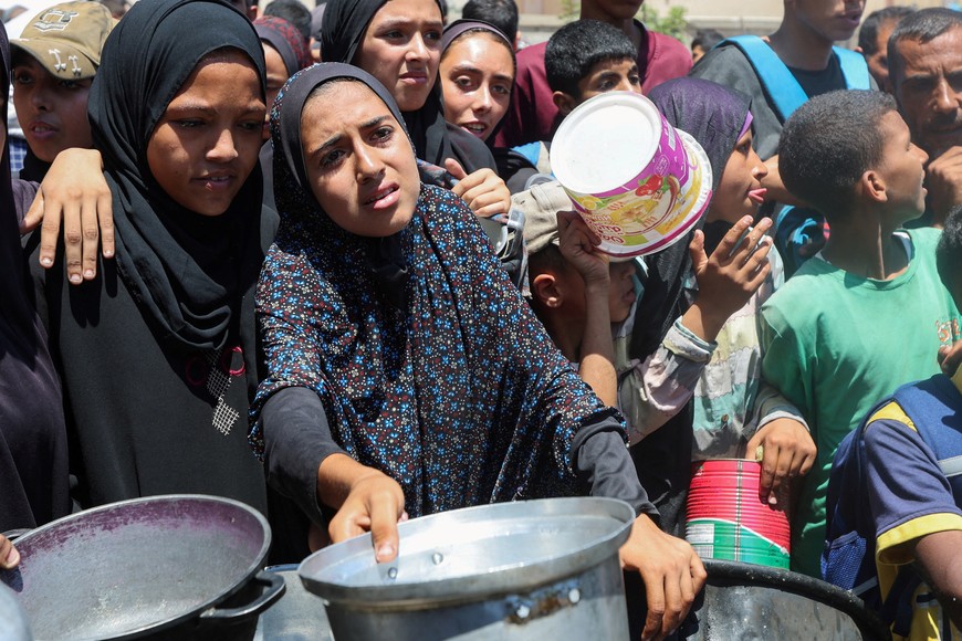 Palestinians gather to receive food from a charity kitchen, amid a hunger crisis, in Nuseirat, central Gaza Strip, July 20, 2025. REUTERS/Ramadan Abed