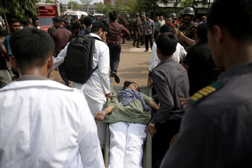 Volunteers rescue an injured girl, after an air force training aircraft crashed into Milestone College campus, in Dhaka, Bangladesh, July 21, 2025. REUTERS/Stringer     TPX IMAGES OF THE DAY