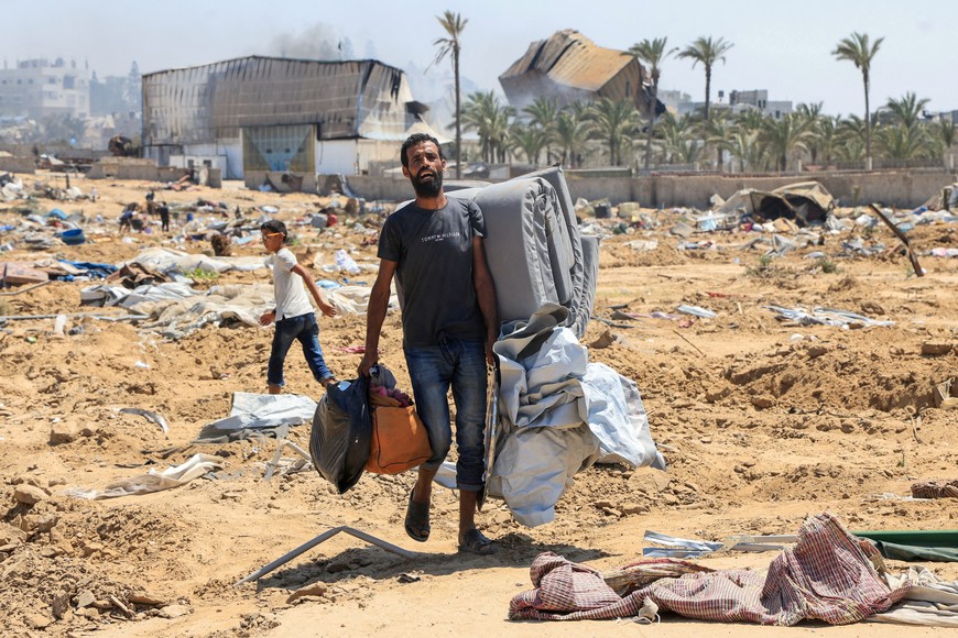 A displaced Palestinian walks in the aftermath of an Israeli military operation in Deir Al-Balah, in the central Gaza Strip, July 22, 2025. REUTERS/Hatem Khaled     TPX IMAGES OF THE DAY