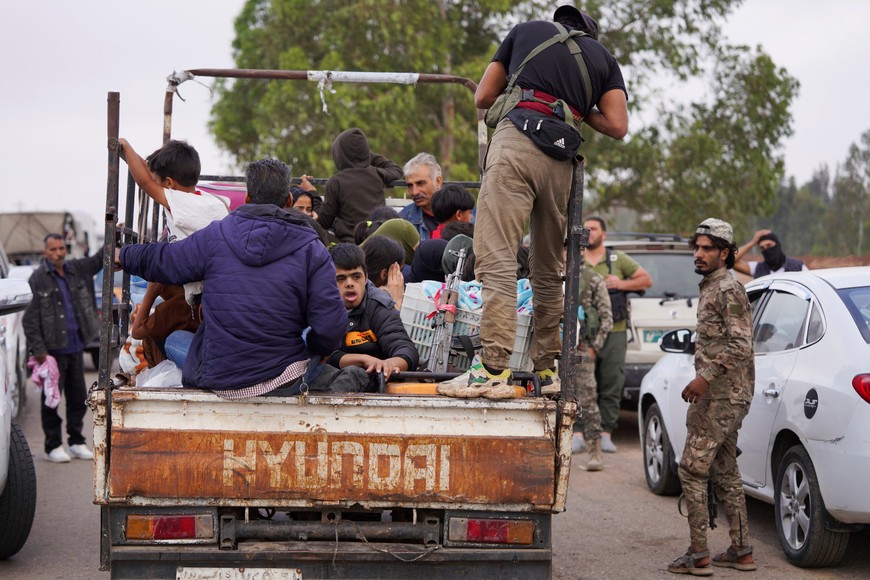 Bedouin families ride in a vehicle with belongings as they leave the village of Al-Mazraa, as residents reported calm in Syria's Sweida on Sunday after the Islamist-led government announced that Bedouin fighters had withdrawn from the predominantly Druze city and a U.S. envoy signaled that a deal to end days of fighting was being implemented, in Sweida, Syria, July 21, 2025. REUTERS/Karam al-Masri