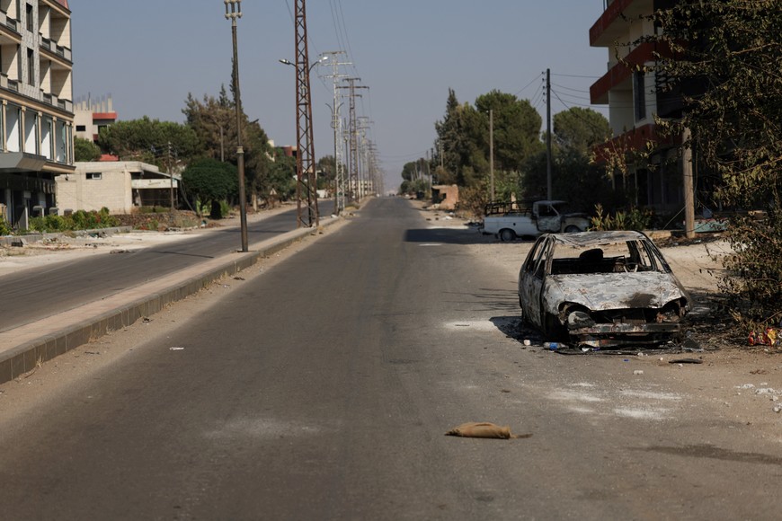 A view of an empty street and the charred remains of a vehicle in the village of Al-Mazra'a, after days of violence in the Sweida province sparked by clashes between Bedouin fighters and Druze factions, in Sweida province, Syria, July 21, 2025. REUTERS/Khalil Ashawi