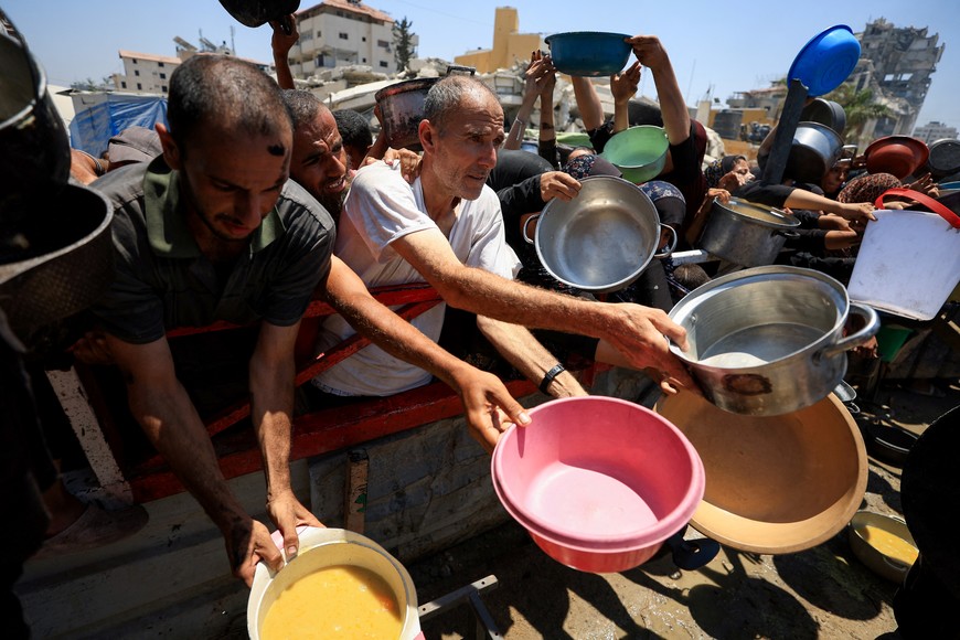 Palestinians gather to receive food from a charity kitchen, amid a hunger crisis, in Gaza City, July 22, 2025. REUTERS/Dawoud Abu Alkas