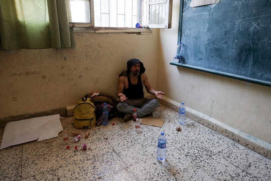 A member of a group of Bedouin families, who left the town of Shahba in Sweida Governorate as part of an agreement between the Syrian government and Druze militants, sits in a school that is used as a shelter centre, in the village of Nahtah in Deraa Governorate, Syria July 21, 2025. REUTERS/Khalil Ashawi