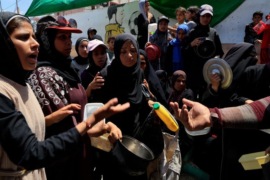 Palestinians gather to receive food from a charity kitchen, amid a hunger crisis, in Nuseirat, central Gaza Strip, July 29, 2025. REUTERS/Hatem Khaled