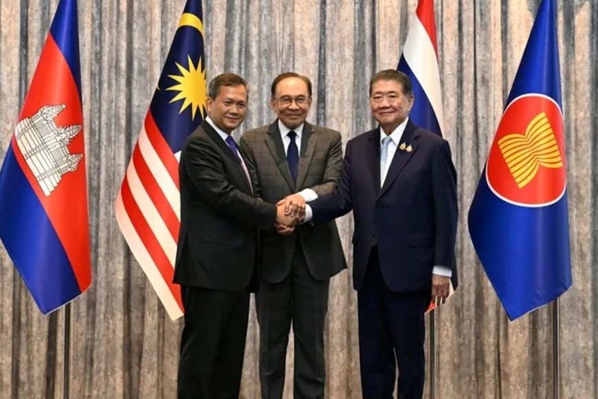 Los primeros ministros de Camboya (d) y Tailandia (i) sellan con un apretón de manos el acuerdo del alto el fuego, en presencia de su homólogo malayo (c) este lunes en Kuala Lumpur. Crédito: EFE/EPA/Mohd Rasfan