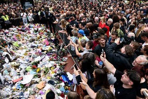 People gather around tributes placed at the Black Sabbath Bridge, named in honour of the heavy metal band, on the day of the funeral cortege of Ozzy Osbourne, its former frontman, in Birmingham, Britain, July 30, 2025. REUTERS/Jack Taylor     TPX IMAGES OF THE DAY
