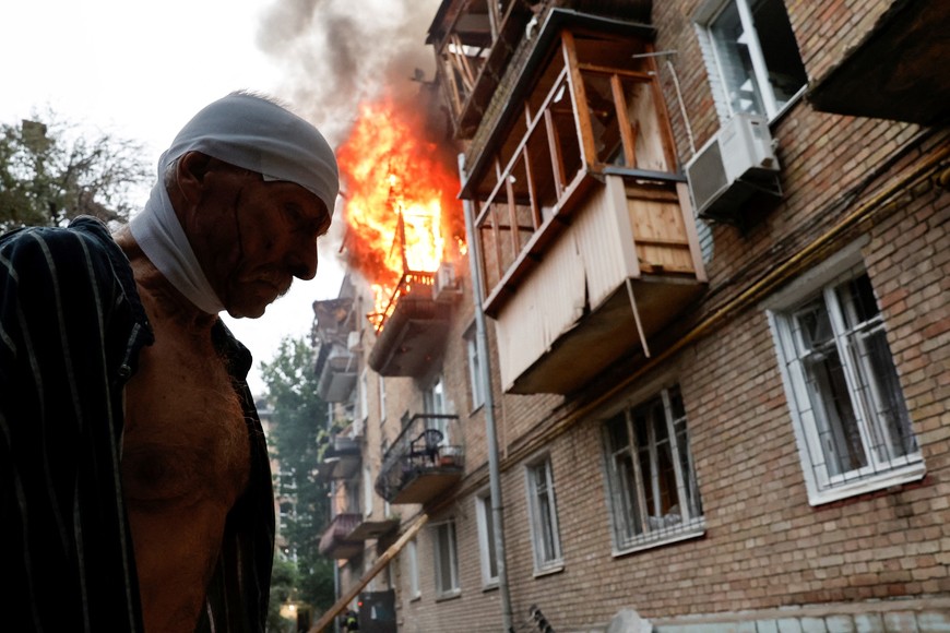 An injured resident stands outside his damaged house during Russian missile and drone strikes, amid Russia's attack on Ukraine, in Kyiv, Ukraine July 31, 2025. REUTERS/Thomas Peter