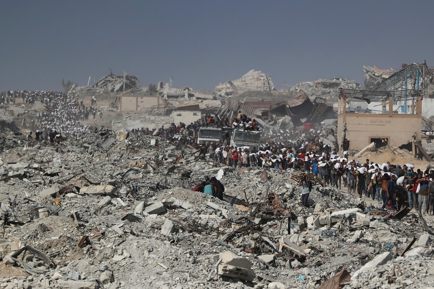 Palestinians carry aid supplies that entered Gaza through Israel, in Beit Lahia, northern Gaza Strip, August 2, 2025. REUTERS/Mahmoud Issa
