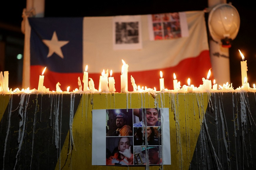 A print showing photos of miners trapped in the El Teniente mine complex, operated by Chilean state-run copper producer Codelco, is displayed during a candlelight vigil as rescue teams continue efforts to reach those trapped following a tremor at the Andesita unit, in Maitenes, Chile, August 2, 2025. REUTERS/Pablo Sanhueza