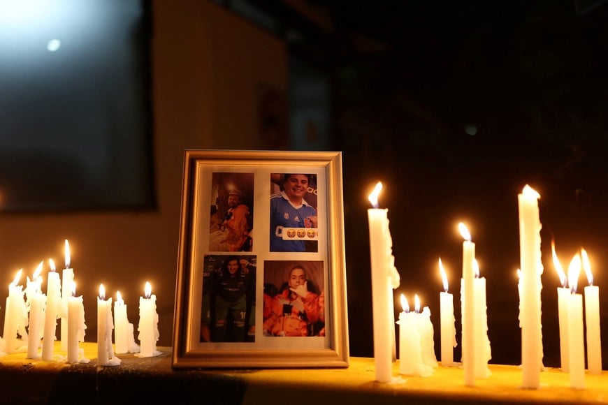 Photographs are displayed as candles burn during a vigil at an entrance to El Teniente mine complex of the Chilean state-run copper producer Codelco, as rescue teams continue efforts to reach miners trapped after a tremor at the Andesita unit, in Maitenes, Chile, August 2, 2025. REUTERS/Pablo Sanhueza