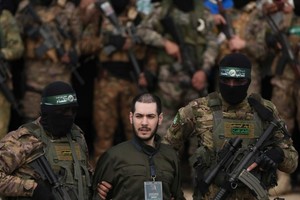 22 de febrero de 2025. Eliya Cohen, rehén retenido en Gaza desde el atentado del 7 de octubre de 2023, es escoltado por miembros del grupo Hamás mientras es liberado como parte de la primera fase del precario alto el fuego de principios de este año.