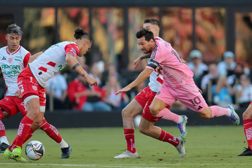 Aug 2, 2025; Fort Lauderdale, FL, USA; Inter Miami CF forward Lionel Messi (10) goes down after dribbling the ball against Necaxa defender Alexis Pena (4) and Necaxa midfielder Raul Sanchez (11)  during the first half of a Leagues Cup group stage match at Chase Stadium. Mandatory Credit: Sam Navarro-Imagn Images