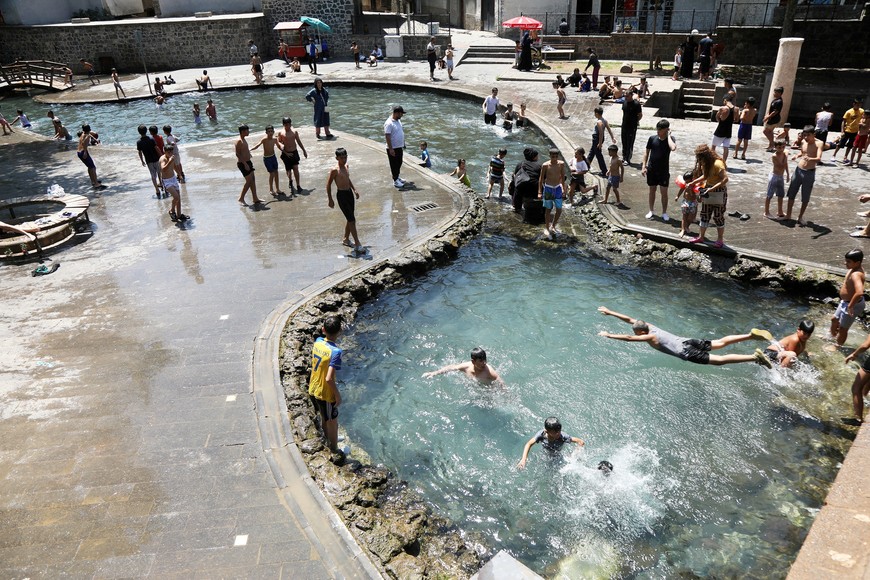 FILE PHOTO: Boys gather to cool off in a pool during a heatwave in the southeastern city of Diyarbakir, Turkey, July 22, 2025. REUTERS/Sertac Kayar/File Photo