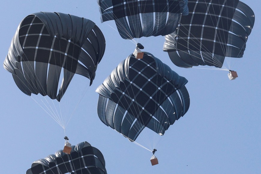 Aid packages dropped from an airplane descend over Gaza, in Deir Al-Balah, in the central Gaza Strip August 12, 2025. REUTERS/Ramadan Abed