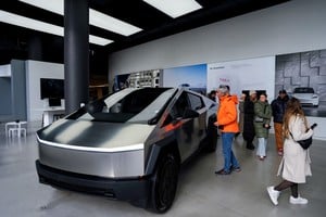 FILE PHOTO: People look at a Tesla Cybertruck at a Tesla showroom in New York City, U.S., January 2, 2025. REUTERS/Adam Gray/File Photo