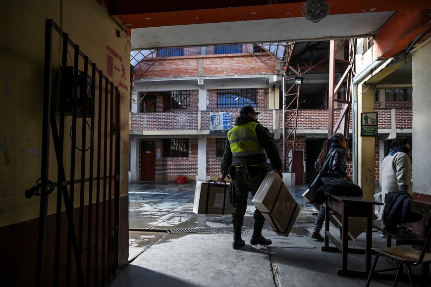 A police officer carries electoral material to be delivered to polling stations, ahead of the general election scheduled for August 17, in El Alto, Bolivia August 16, 2025. REUTERS/Claudia Morales