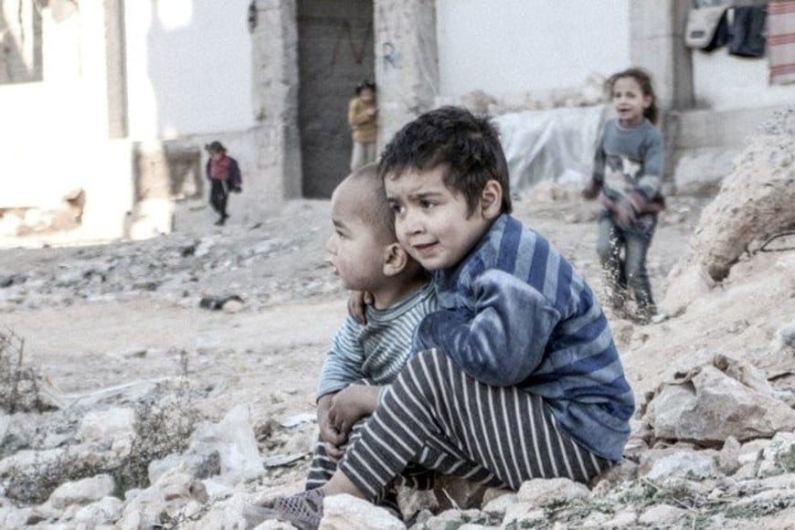 Niños de la guerra civil de Siria. Esta fotografía fue captada en 2018, cuando los hermanitos Esraa y Waleed, que por entonces tenían cuatro y tres años, se abrazan sentados cerca de un refugio para desplazados internos en Alepo. UN News