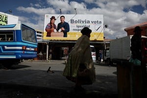 A woman walks past a banner, ahead of Bolivia's general election to be held on August 17, in El Alto, Bolivia August 15, 2025. REUTERS/Pilar Olivares