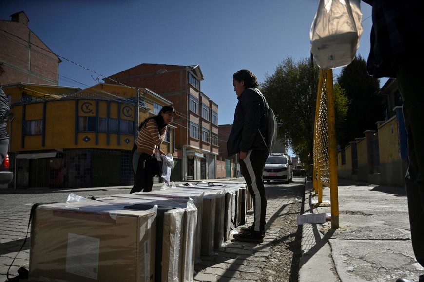 Workers of the Departmental Electoral Tribunal (TED) stand by electoral material outside a polling station, ahead of the general election scheduled for August 17, in El Alto, Bolivia August 16, 2025. REUTERS/Claudia Morales