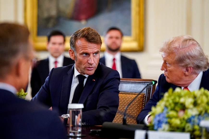 French President Emmanuel Macron speaks to U.S. President Donald Trump during a meeting with Ukrainian President Volodymyr Zelenskiy (not pictured) and European leaders amid negotiations to end the Russian war in Ukraine, at the White House in Washington, D.C., U.S., August 18, 2025. REUTERS/Al Drago