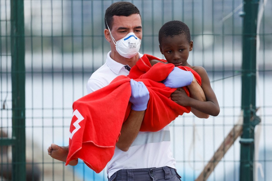 A Red Cross nurse helps a minor migrant to disembark from a Spanish coast guard vessel at the port of Arguineguin, on the island of Gran Canaria, Spain, March 28, 2024. REUTERS/Borja Suarez