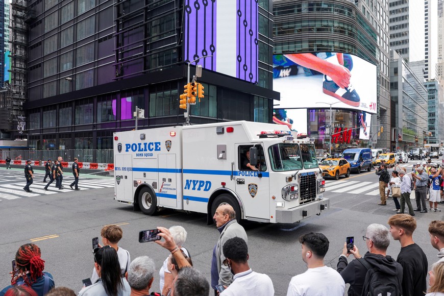 People use their mobile phones as police vehicles block a street in a cordoned off area in Times Square in New York City, U.S. August 18, 2025. REUTERS/Jeenah Moon