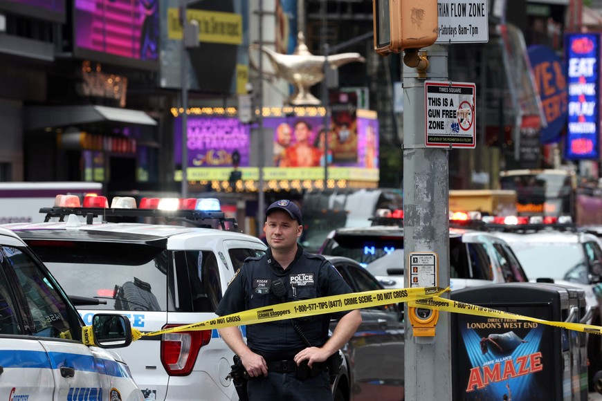 A member of the NYPD stands as emergency responders work at the scene of  a suspicious package in Times Square in New York City, U.S., August 18, 2025. REUTERS/Brendan McDermid