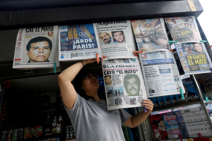 FILE PHOTO: A newspaper seller arranges newspapers reporting the El Paso, Texas, U.S., arrest of Mexican drug lord Ismael "El Mayo" Zambada and Joaquin Guzman Lopez, "El Chapo" Guzman's son, in Mexico City, Mexico July 26, 2024. REUTERS/Gustavo Graf/File Photo