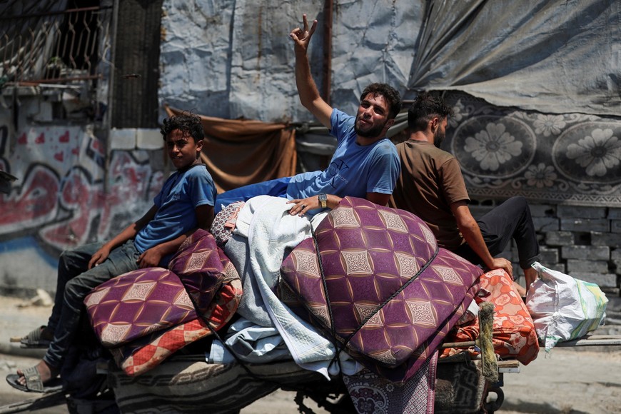 Displaced Palestinians travel on a cart loaded with belongings as they flee amid an Israeli military operation, in Gaza City, August 22, 2025. REUTERS/Mahmoud Issa