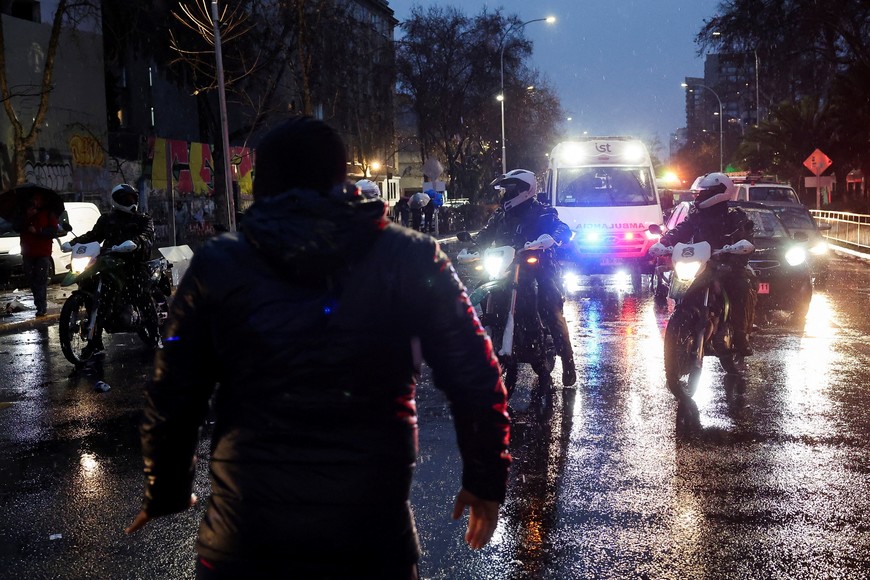 Police escort University of Chile fans as they gather outside Argentina's embassy after fellow fans were detained in Argentina following clashes with Independiente supporters, during the second leg of the Copa Sudamericana Round of 16 match, which was suspended due to violence in the stands, in Santiago, Chile August 21, 2025. REUTERS/Pablo Sanhueza