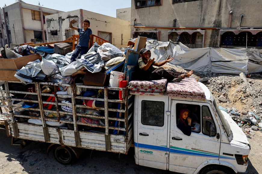 Displaced Palestinians travel on a vehicle loaded with belongings as they flee amid an Israeli military operation, in Gaza City, August 22, 2025. REUTERS/Mahmoud Issa