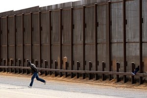 Migrants try to enter the United States undetected, through a hole in a section of the U.S.-Mexico border wall, in Sunland Park, New Mexico, U.S., January 28, 2025. REUTERS/Jose Luis Gonzalez