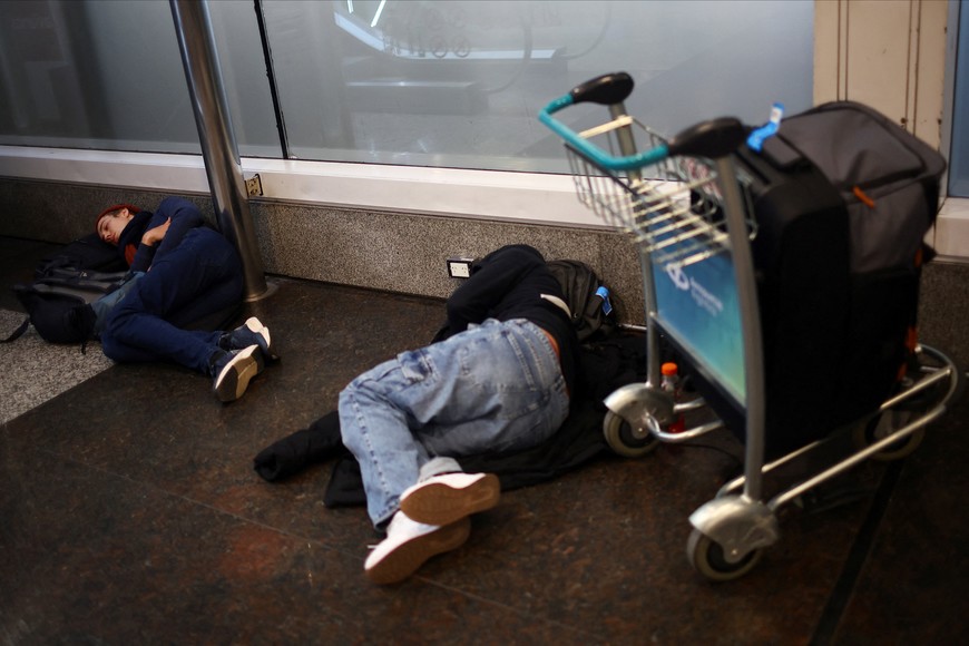 People rest at Aeroparque Internacional Jorge Newbery airport as Argentine air traffic controllers strike for improved working conditions and higher wages, in Buenos Aires, Argentina, August 26, 2025. REUTERS/Agustin Marcaria