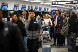 A man holds his luggage as he waits in line at the Aeroparque International Jorge Newbery airport as Argentine air traffic controllers strike for improved working conditions and higher wages, in Buenos Aires, Argentina, August 26, 2025. REUTERS/Agustin Marcarian
